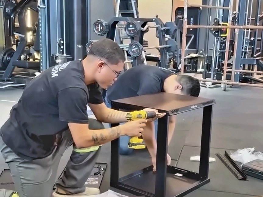 Equipe da Esparta Engenharia montando o mobiliário da academia Esparta Fit Body
